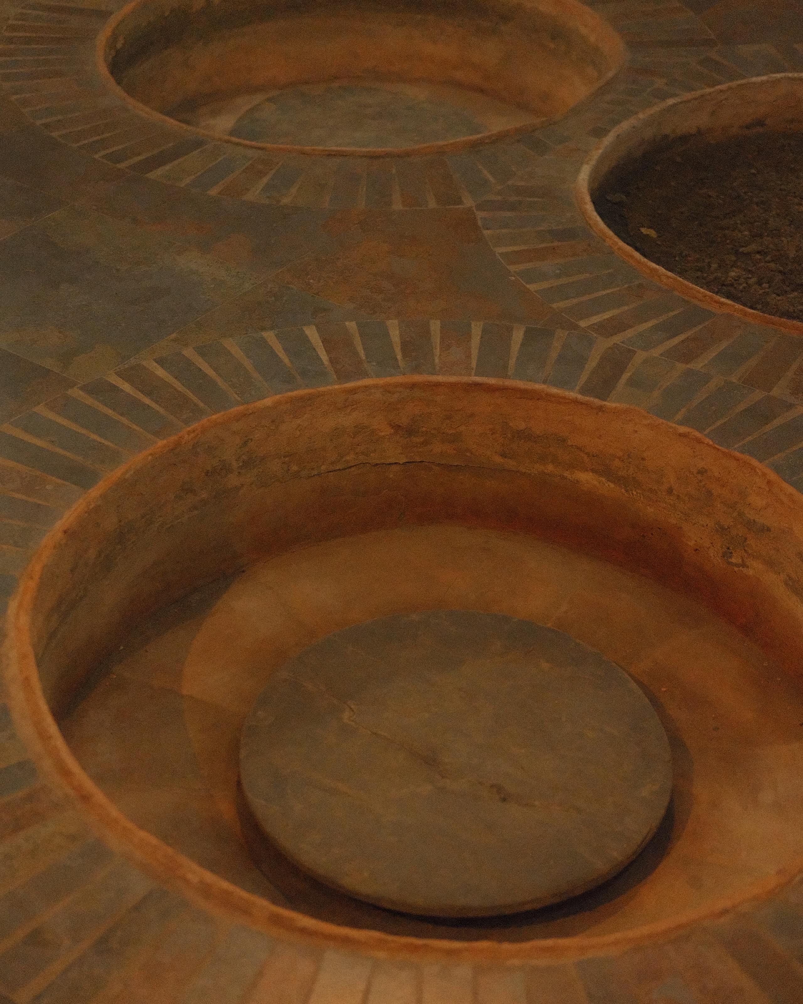 A monk tending qvevri in Alaverdi’s historic cellar